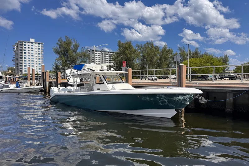 Slide: The Image of 2016 Everglades 435 Center Console boat docked at marina under blue sky. - 2