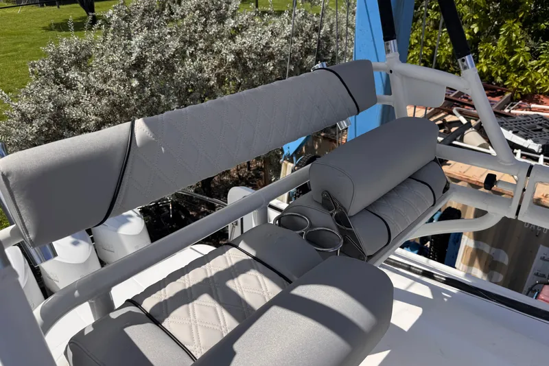 Slide: The Image of 2016 Everglades 435 Center Console boat seating with cup holders, featuring gray upholstery. - 24