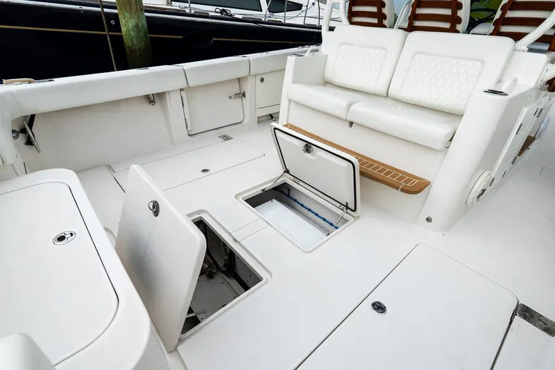 Slide: The Image of 2021 Jupiter 43 boat interior with open storage compartments and cushioned seating. - 24