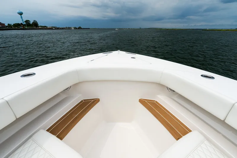 Slide: The Image of Bow view of 2021 Jupiter 43 boat on open water under cloudy sky. - 50