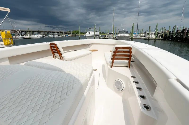 Slide: The Image of Luxurious 2021 Jupiter 43 boat interior with plush seating, docked under stormy skies. - 47