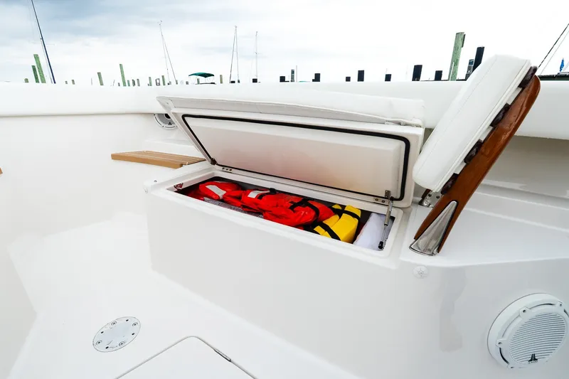 Slide: The Image of Open storage compartment on 2021 Jupiter 43 boat with life jackets inside. - 56