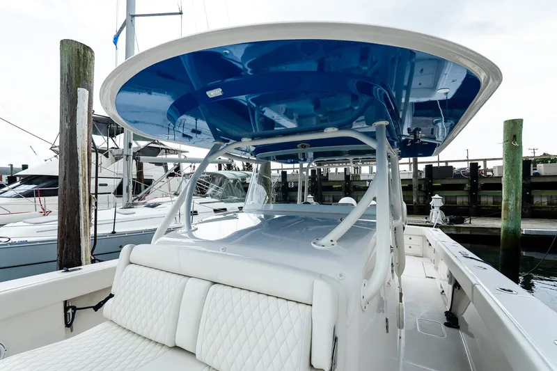 Slide: The Image of 2021 Jupiter 43 boat with blue canopy, docked at marina. - 31