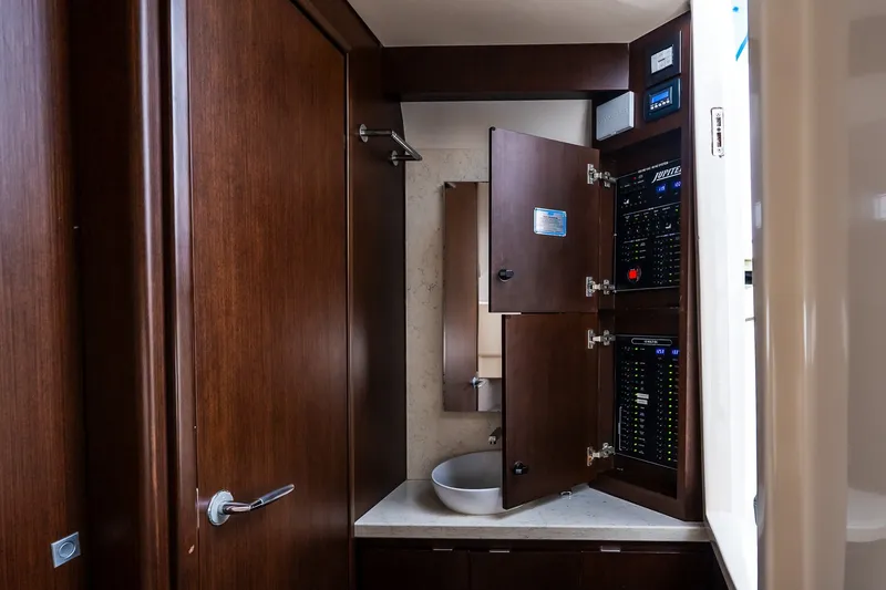 Slide: The Image of 2021 Jupiter 43 yacht interior with open electrical panel and wooden cabinetry. - 67