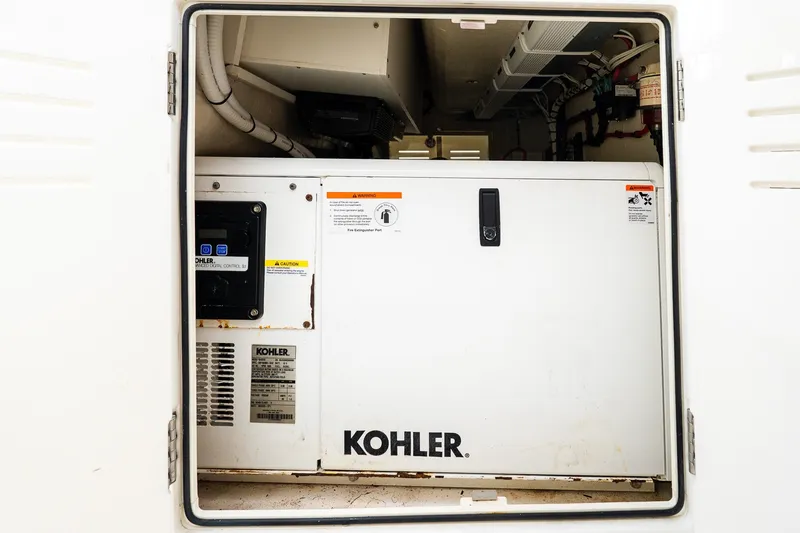 Slide: The Image of Kohler generator inside Jupiter 43 yacht, 2021 model, with control panel and safety warnings. - 72
