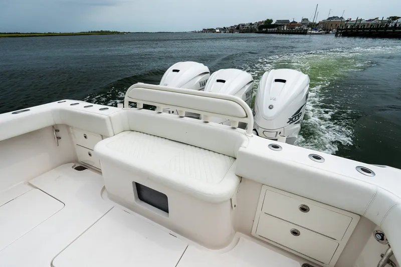 Slide: The Image of 2021 Jupiter 43 boat with triple outboard engines cruising on water. - 15