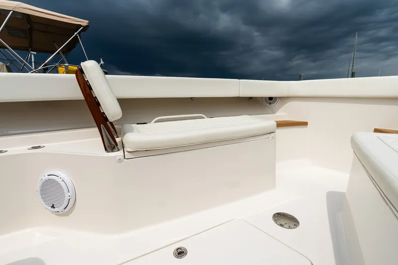 Slide: The Image of 2021 Jupiter 43 boat interior with white seating and stormy sky background. - 52