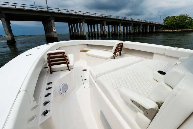 Slide: The Image of Luxurious 2021 Jupiter 43 boat interior with plush seating, near a bridge over calm waters. - 49