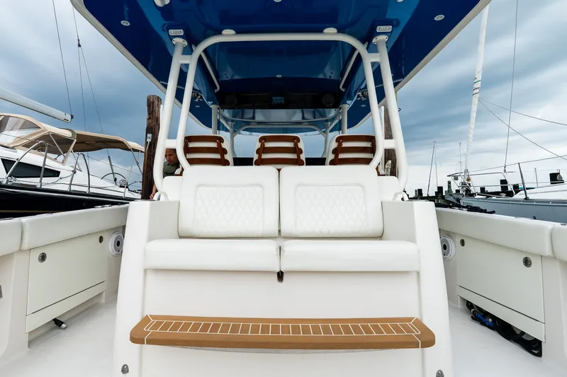 Slide: The Image of 2021 Jupiter 43 boat interior with white seating and blue canopy, docked at marina. - 26