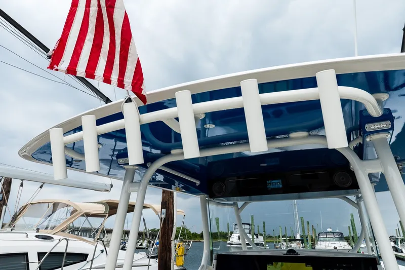 Slide: The Image of American flag on a 2021 Jupiter 43 boat, docked with other vessels in the background. - 33