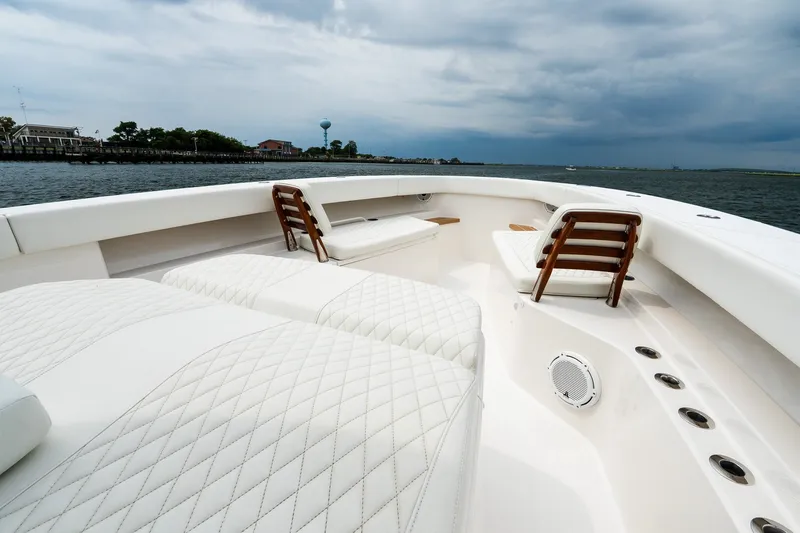 Slide: The Image of Luxurious 2021 Jupiter 43 boat interior with white quilted seating on a cloudy day. - 54