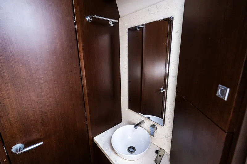 Slide: The Image of Modern bathroom interior with wooden cabinetry, round sink, and mirror in Jupiter 43, 2021 model. - 66