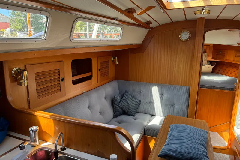 Slide: The Image of Interior of a 1995 Hallberg-Rassy 34 sailboat with wooden finishes and seating area. - 16