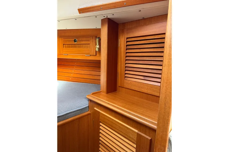 Slide: The Image of Interior of 1995 Hallberg-Rassy 34 sailboat with wooden cabinetry and cozy sleeping area. - 14