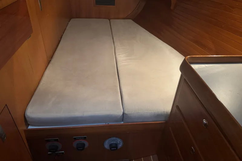 Slide: The Image of Interior cabin of 1998 J Boats J/160 with wooden paneling and cushioned bed. - 17