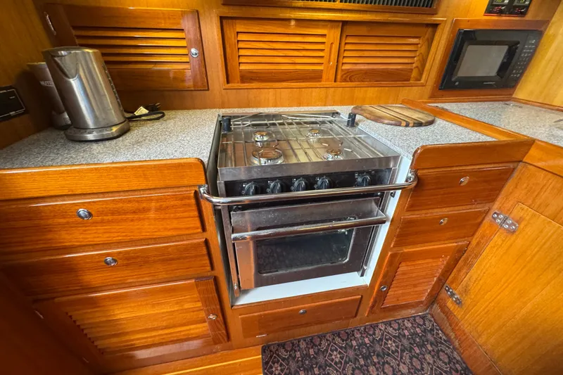 Slide: The Image of Wooden yacht kitchen with stove, microwave, and kettle on J Boats J/160, 2020 model. - 12