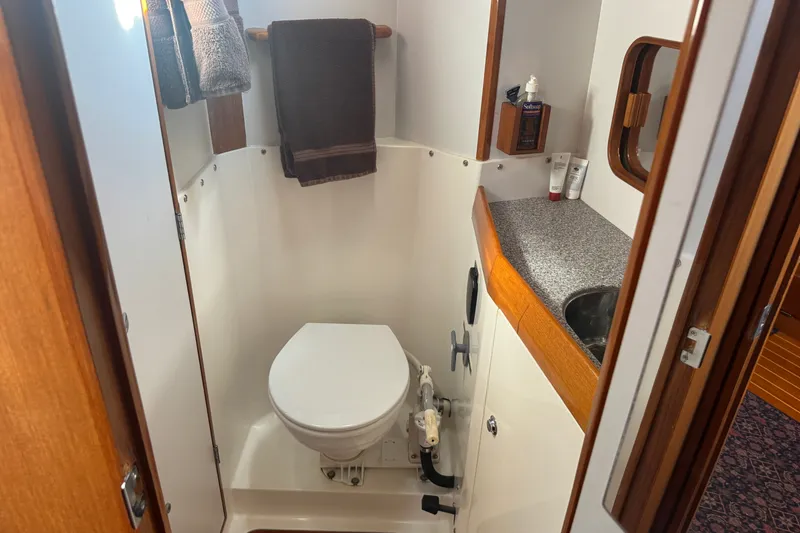 Slide: The Image of Compact bathroom in 2020 J Boats J/160 yacht with toilet, sink, and wooden accents. - 9