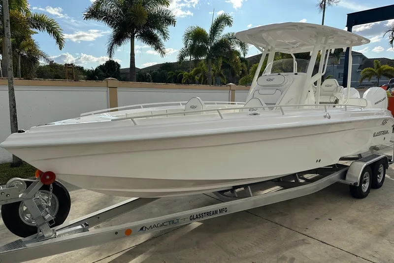Slide: The Image of 2025 Glasstream 280 Pro-XS boat on trailer, parked outdoors with palm trees in background. - 8