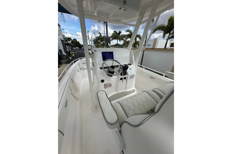 Slide: The Image of 2025 Glasstream 280 Pro-XS boat interior with steering console and seating, under a clear sky. - 15