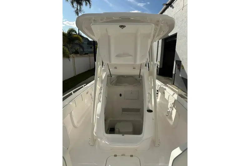 Slide: The Image of 2025 Glasstream 280 Pro-XS boat interior with open storage compartment, docked outdoors. - 22
