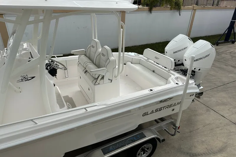 Slide: The Image of 2025 Glasstream 280 Pro-XS boat with dual Mercury engines, white interior, and trailer. - 10