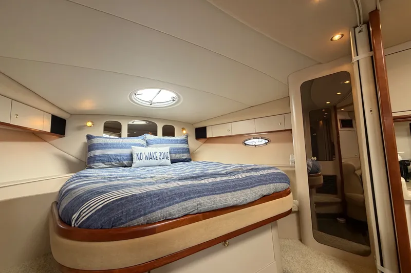 Slide: The Image of Luxurious cabin interior of 2000 Cruisers Yachts 3870 Express with cozy bed and nautical decor. - 16