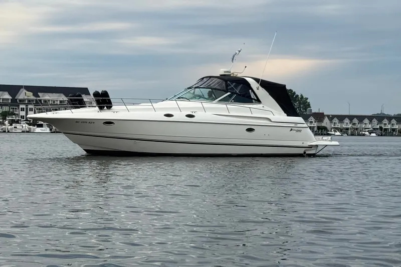The Image of 2000 Cruisers Yachts 3870 Express on calm water with scenic background. - 0