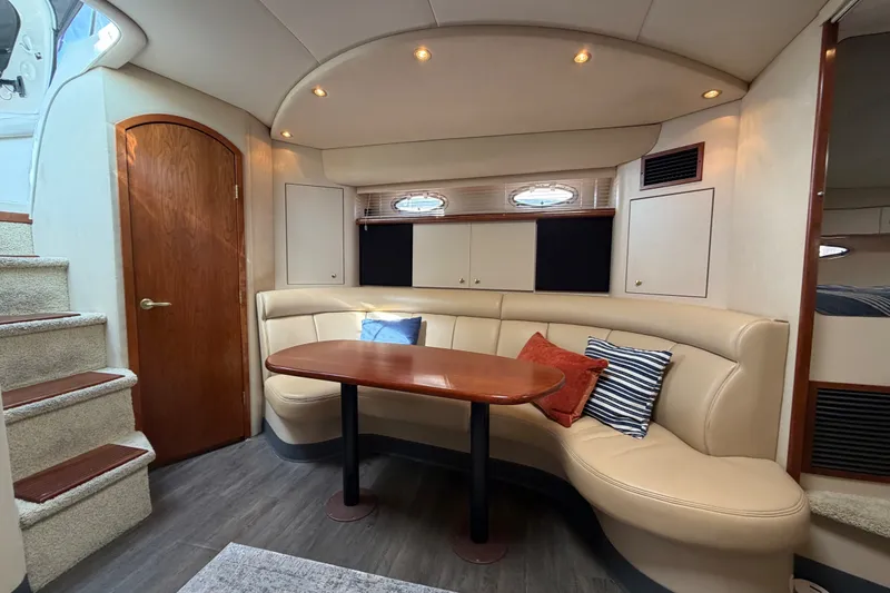Slide: The Image of Interior of 2000 Cruisers Yachts 3870 Express with cozy seating and wooden table. - 12