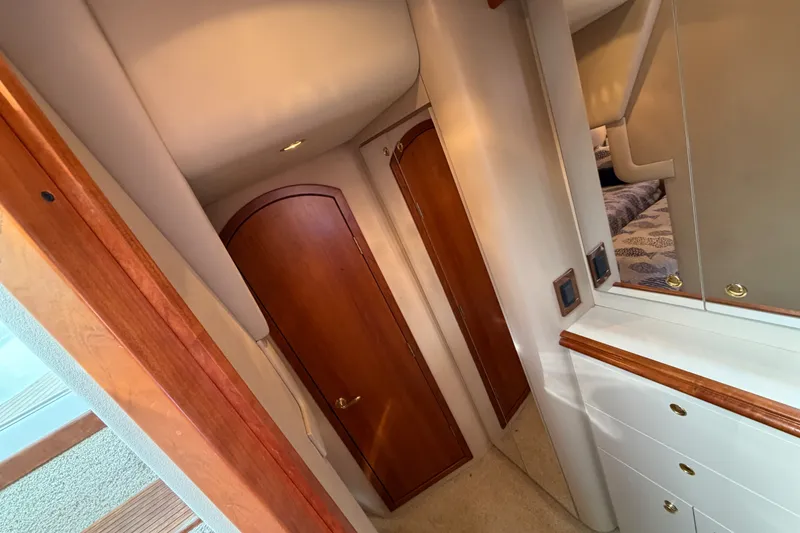 Slide: The Image of Interior of 2000 Cruisers Yachts 3870 Express, featuring wooden doors and mirrored cabinetry. - 21