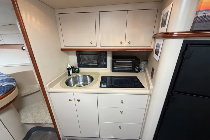Slide: The Image of Compact kitchen area in a 2000 Cruisers Yachts 3870 Express, featuring sink and appliances. - 14
