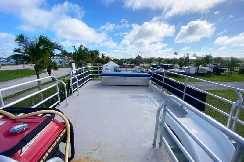 Slide: The Image of 2019 Solid Craft Commercial Pontoon deck with railings, palm trees, and blue sky background. - 24
