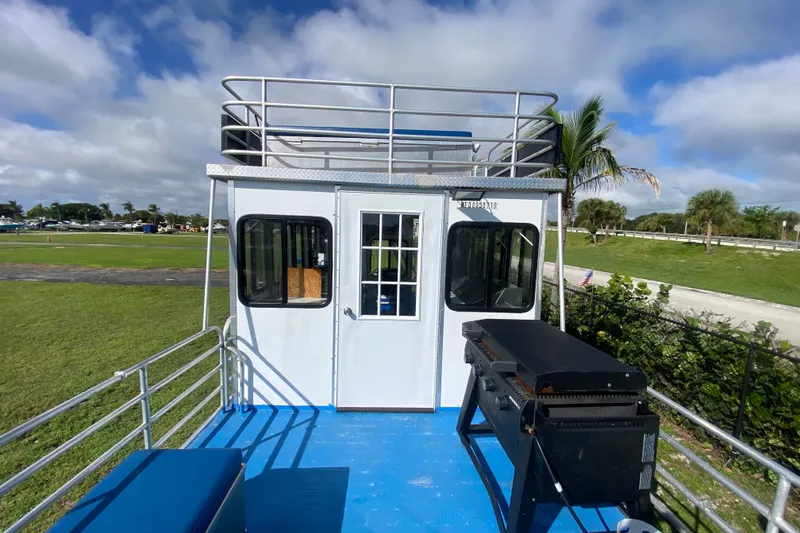 Slide: The Image of 2019 Solid Craft Commercial Pontoon with upper deck and grill, set in a scenic park. - 21