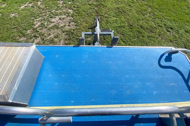 Slide: The Image of 2019 Solid Craft Commercial Pontoon deck with blue flooring and metal railing. - 23