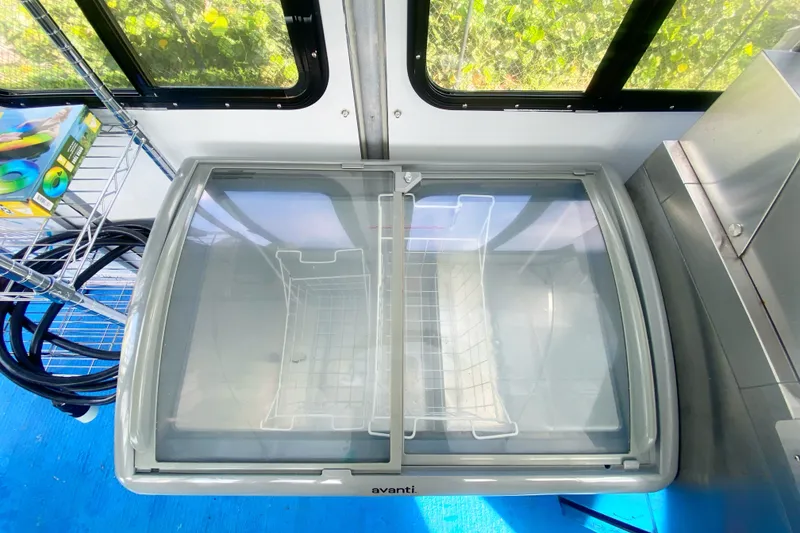 Slide: The Image of Commercial pontoon interior with Avanti freezer, shelving, and blue flooring, 2019 Solid Craft model. - 14