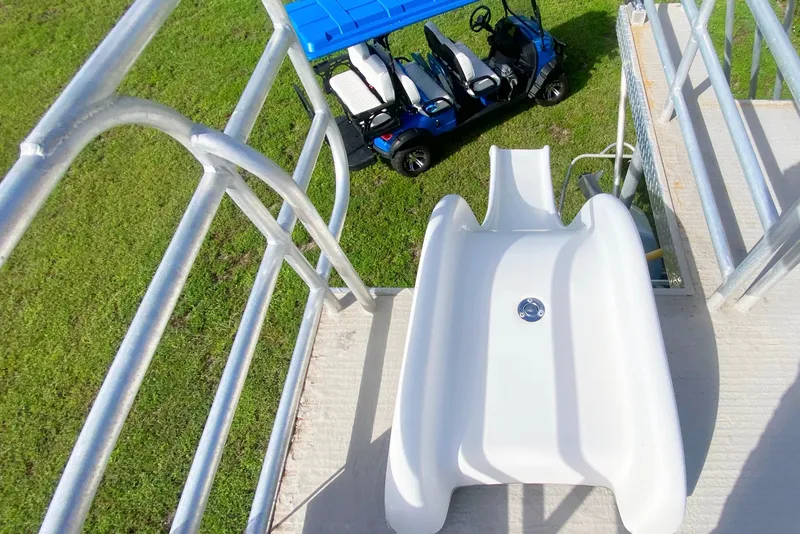 Slide: The Image of White slide on a pontoon boat with a blue golf cart nearby. - 26