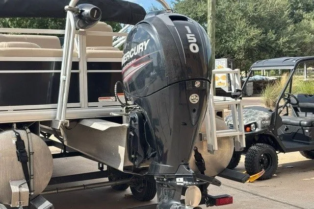 Slide: The Image of 2019 Sun Tracker Fishin' Barge 24 DLX with Mercury 50 outboard motor, parked outdoors. - 17