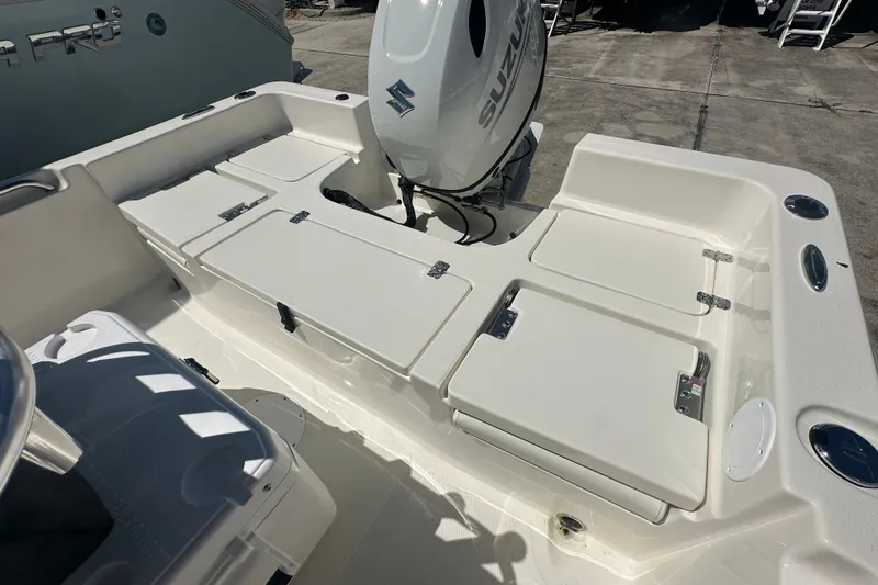 Slide: The Image of 2027 Bulls Bay 2000 XS boat deck with Suzuki outboard motor, featuring storage compartments. - 13