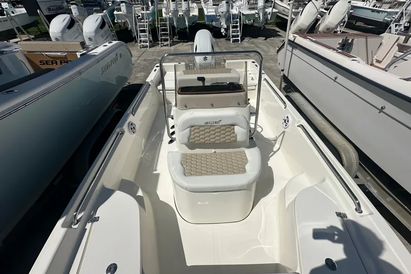 Slide: The Image of 2027 Bulls Bay 2000 XS boat interior with seating and console, displayed at a marina. - 10