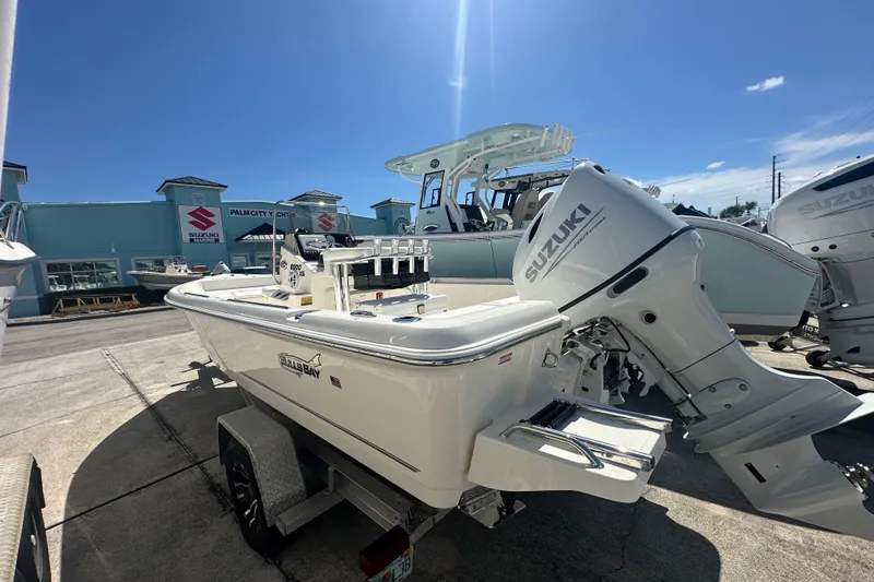 Slide: The Image of 2027 Bulls Bay 2000 XS boat with Suzuki engine at a dealership under clear blue sky. - 5