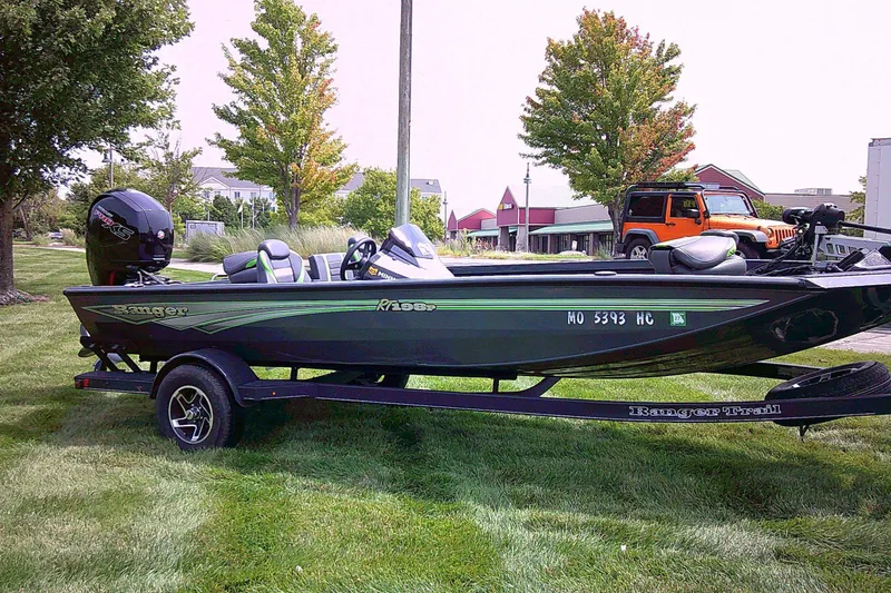 Slide: The Image of 2025 Ranger RT198P boat on trailer, parked on grass with trees and buildings in background. - 5
