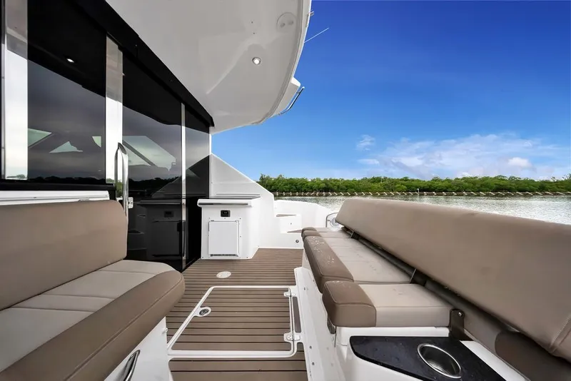 Slide: The Image of 2014 Regal 42 Sport Coupe yacht interior with seating, sleek design, and scenic water view. - 50