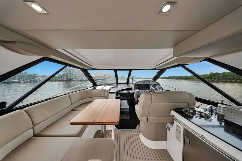 Slide: The Image of Luxurious interior of a 2014 Regal 42 Sport Coupe yacht with panoramic windows and elegant seating. - 53