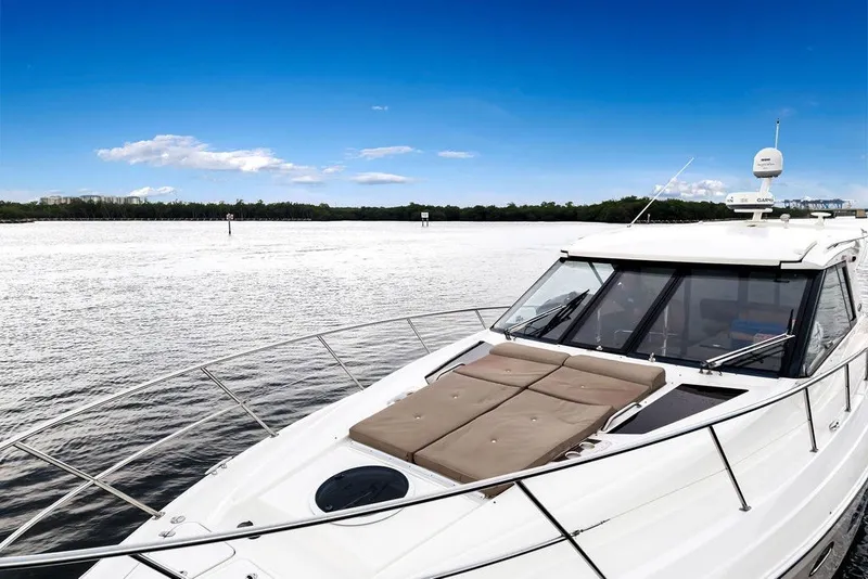 Slide: The Image of 2014 Regal 42 Sport Coupe yacht on calm water under clear blue sky. - 30