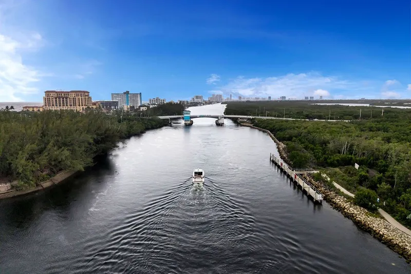 Slide: The Image of A 2014 Regal 42 Sport Coupe cruising on a scenic river with city skyline. - 34