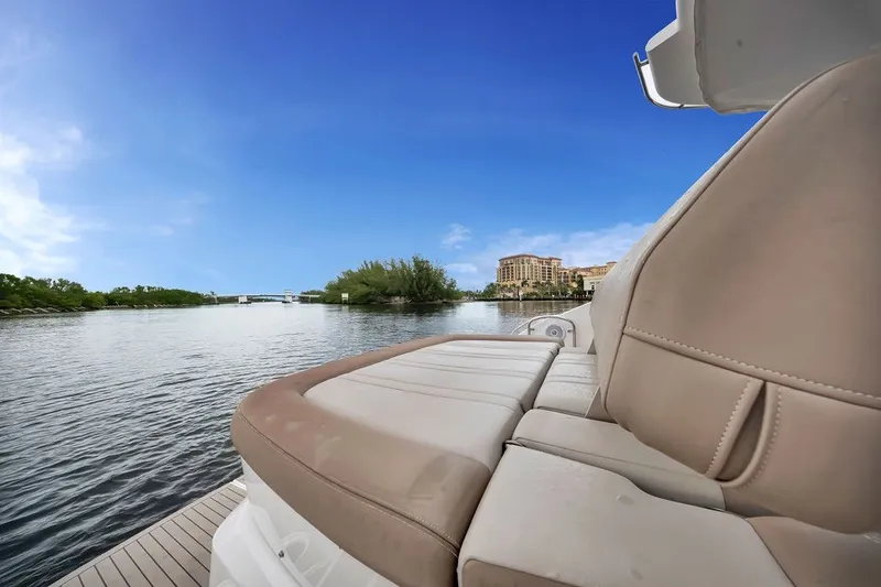 Slide: The Image of 2014 Regal 42 Sport Coupe yacht with scenic waterfront view and clear blue sky. - 46
