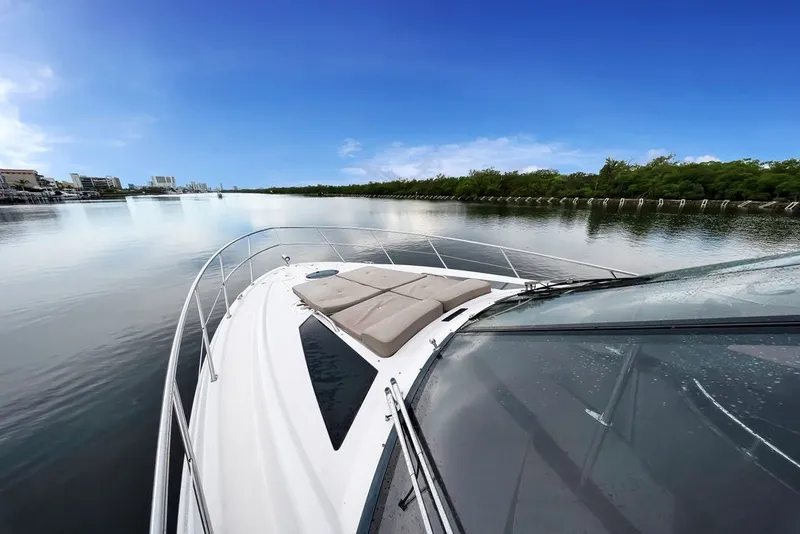Slide: The Image of 2014 Regal 42 Sport Coupe cruising on a calm river under a clear blue sky. - 51