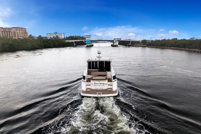 Slide: The Image of 2014 Regal 42 Sport Coupe cruising on a scenic river under a clear blue sky. - 36