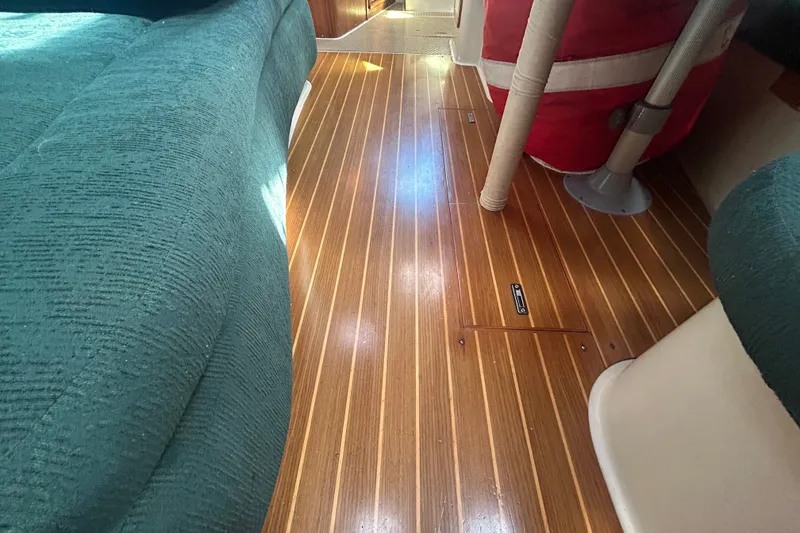 Slide: The Image of Interior of a 1997 Catalina 380 sailboat with polished wooden flooring and green upholstery. - 17