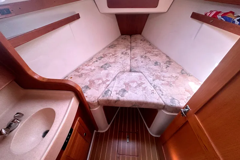 Slide: The Image of Interior cabin of a 1997 Catalina 380 sailboat with a cozy V-berth. - 13