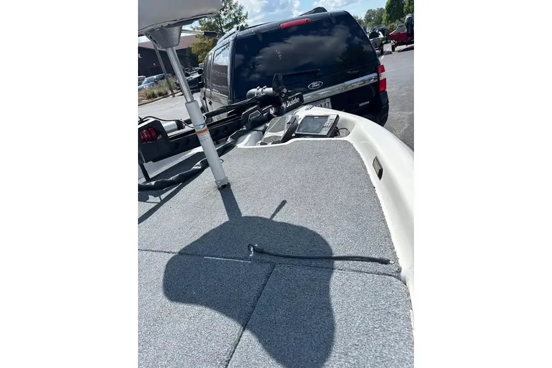 Slide: The Image of 2004 Bass Cat Pantera Classic boat deck with fishing equipment and parked vehicle. - 6